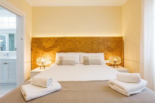 LlumesanasPandora的一间卧室配有一张带两盏灯的大型白色床。