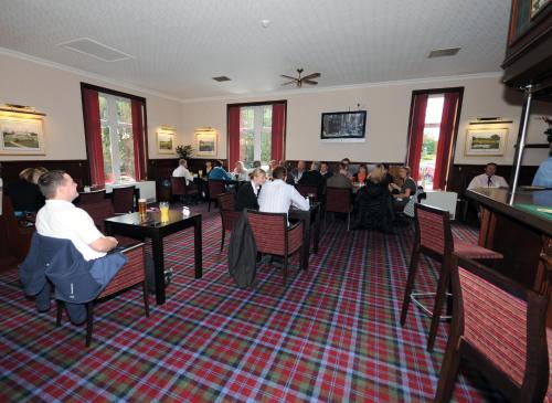 戴斯Pinehurst Lodge Hotel - Aberdeen的一群坐在餐厅桌子上的人