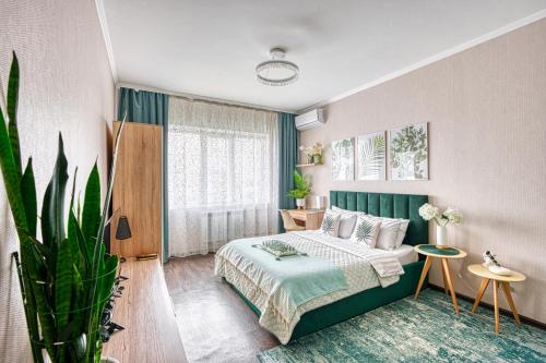 阿拉木图Green Boutique - квартира в мятных оттенках的一间卧室配有一张床和盆栽植物
