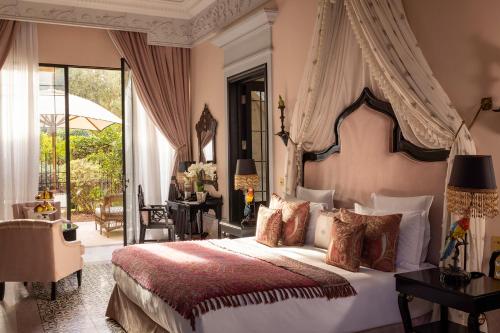 马拉喀什Palais Ronsard Relais & Chateaux的一间卧室配有一张带天蓬的大床