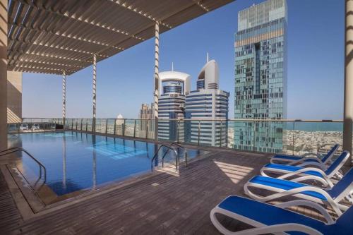 迪拜GuestReady - Top of the World的一座带椅子的建筑屋顶上的游泳池