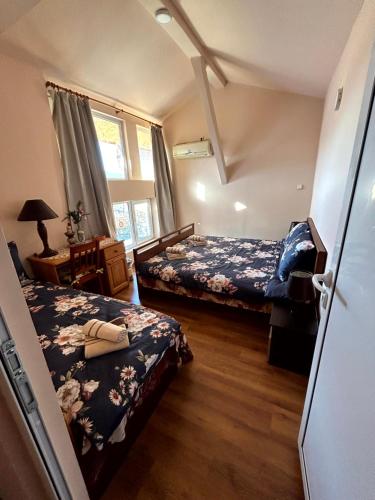 大特尔诺沃Къща за гости Трапезица с безплатен паркинг двор и веранди的一间卧室设有两张床和窗户。
