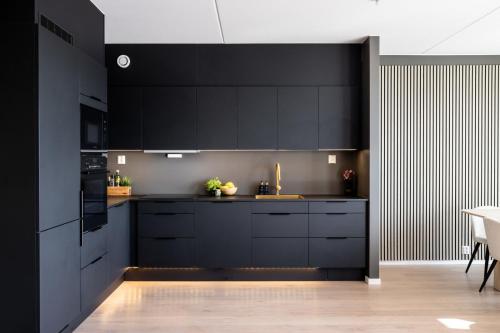 奥斯陆Modern Elegance in Oslo的黑色的厨房,配有黑色橱柜和桌子