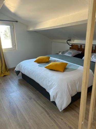 莱博德普罗旺斯Chez Romain et Saphie的一间卧室配有一张带黄色枕头的床。