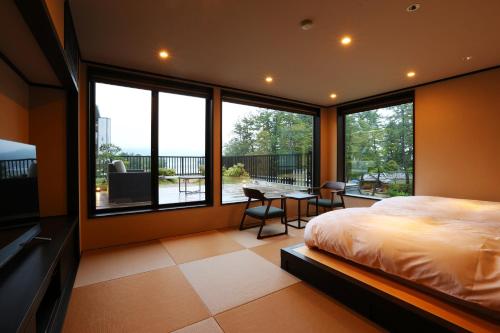 宫津市天桥立对桥楼酒店的卧室配有一张床和一张桌子及椅子