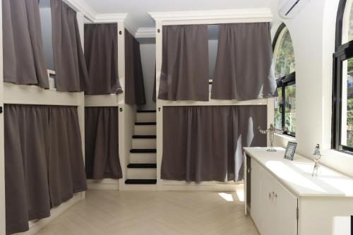 PombasHotel Château Georgette的浴室设有灰色窗帘和楼梯。