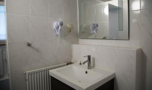 美因河畔法兰克福埃施伯恩霍夫酒店的一间带水槽的浴室和墙上的一部电话