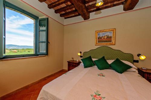 Terontola拉菲奥里塔度假屋的一间卧室配有一张带绿色枕头的床和一扇窗户