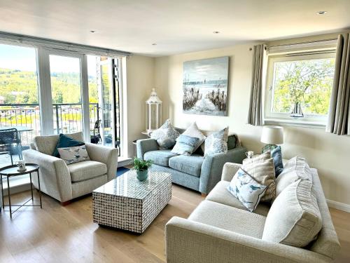 巴洛赫Riverside View Penthouse in Balloch, Loch Lomond的客厅配有两张沙发和一张桌子