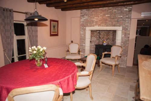 RuiseledeB&B Castel 't Haantje的一间带桌椅和壁炉的用餐室