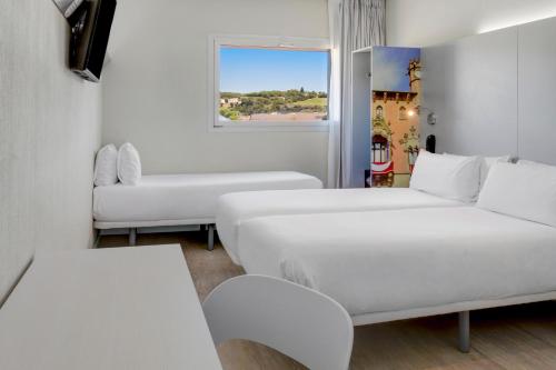 Les Franqueses del VallèsB&B HOTEL Barcelona Granollers的白色的客房配有两张床和一张沙发