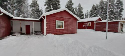 BlattnikseleVindelälv Stuga in Blattnicksele的红房子前面的一堆雪
