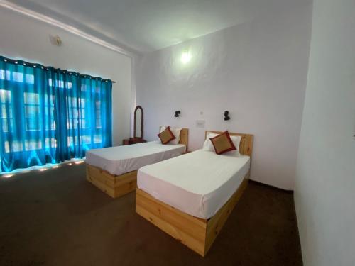 列城Hotel Skittsal Leh的一间卧室设有两张床和窗户。