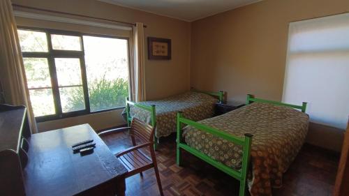 塔里哈Casa 363/ 2-8 personas的客房设有两张床、一张桌子和一扇窗户。