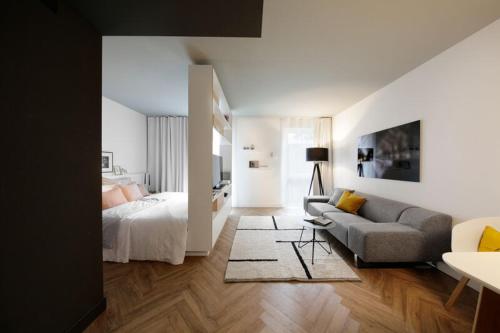 慕尼黑慕尼黑帕克斯塔德施瓦宾商务雅致公寓式酒店的客厅配有床和沙发