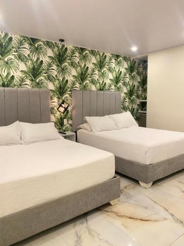 圣安德烈斯WH HOTEL的卧室内的两张床,配有壁纸