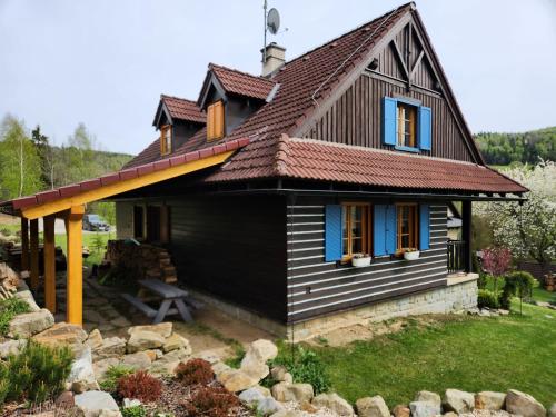 奥什恰德尼察Chata Kolmanovci的一间黑色的小房子,屋顶为棕色