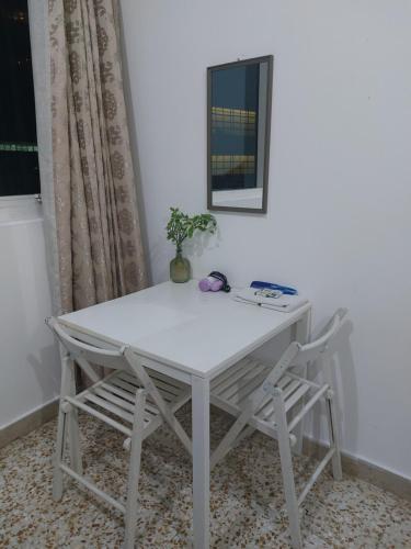阿布扎比Furnished bedroom near Abu Dhabi Corniche的一张带两把椅子和镜子的白色桌子