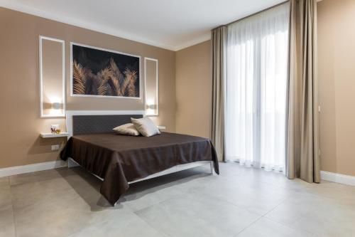 泰拉西尼Le Palme的一间卧室设有一张床和一个大窗户