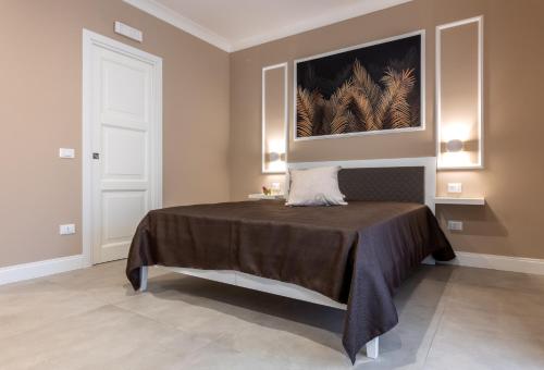 泰拉西尼Le Palme的卧室配有一张床,墙上挂有绘画作品