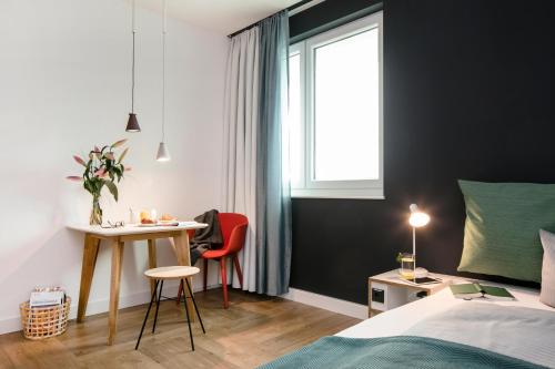 柏林SMARTments business Berlin Prenzlauer Berg的一间卧室配有一张床、一张书桌和一个窗户。