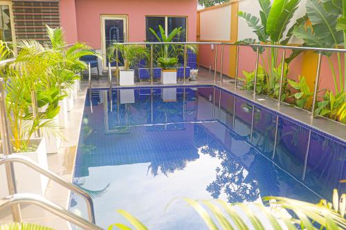 伊凯贾Sugarland Hotel and Suite的一座种植了植物的游泳池