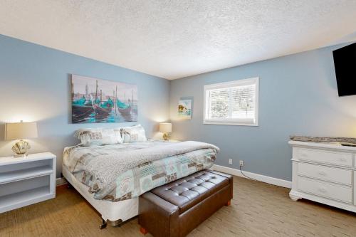 卡农海滩Driftwood的一间拥有蓝色墙壁的卧室、一张床和窗户