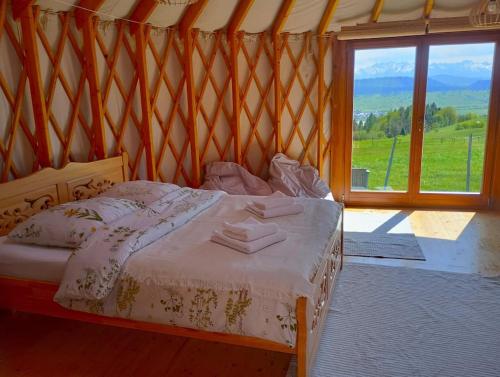 SzlembarkWoda Góry Las - glamping CAŁOROCZNY的一张位于带大窗户的房间内的床铺