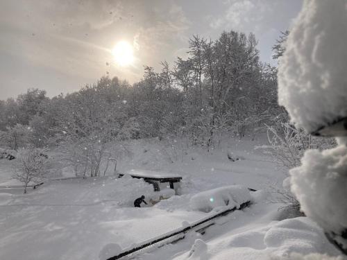 YoichiMinanonno Play Village的雪上遮盖的野餐桌,太阳在背后