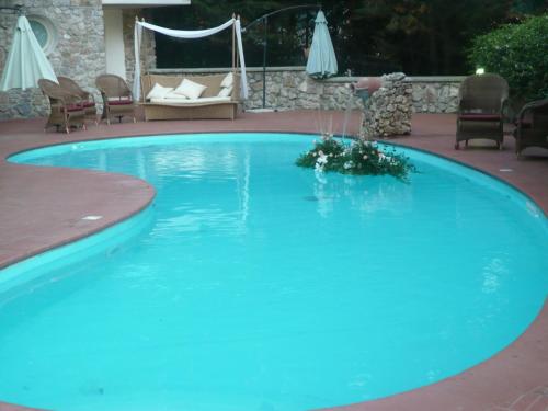 Solofra索罗法皇宫度假酒店的一个带椅子和沙发的大型蓝色游泳池