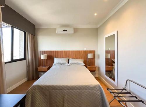 圣保罗Flat Congonhas的一间卧室配有一张大床和镜子