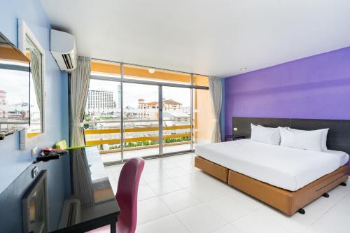 芭堤雅市中心贝拉快捷酒店的一间卧室设有一张床、一台电视和一个窗口。