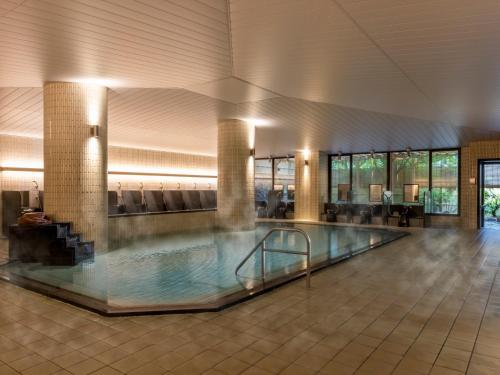 大山Mercure Tottori Daisen Resort & Spa的一座带游泳池的大楼内的大型游泳池