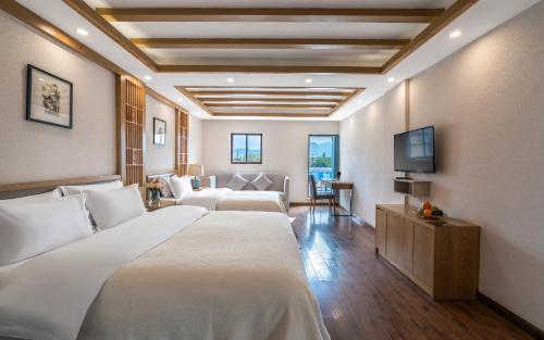 丽江丽江格麦尔精品度假酒店的配有一张床和一台平面电视的酒店客房