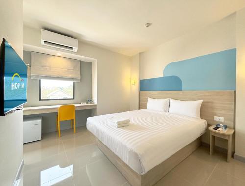 拉差汶里Hop Inn Ratchaburi的配有一张床和一张书桌的酒店客房