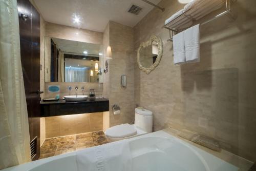 河内The Hanoi Club Hotel & Residences的带浴缸、卫生间和盥洗盆的浴室