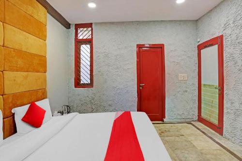 新德里Flagship Kashish Residency的一间卧室配有一张红色门的床