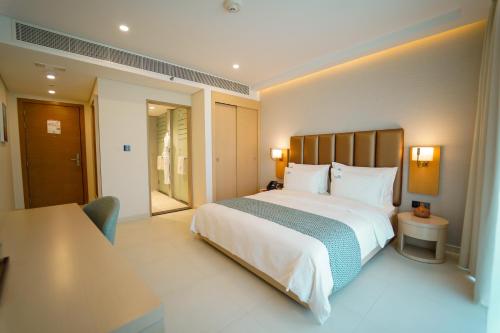 阿吉曼Zoya Health & Wellbeing Resort的卧室配有一张白色的大床和一张桌子