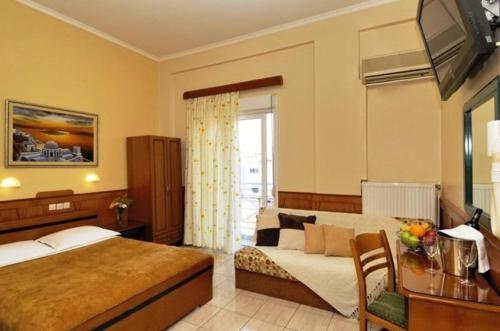 沃洛斯阿德米托斯酒店的一间卧室配有一张床、一张书桌和一台电视