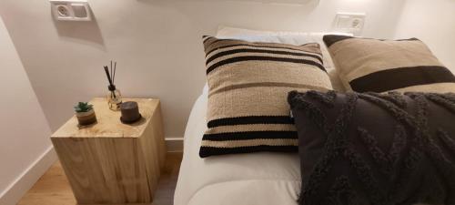马德里La Casita del Retiro的一间卧室配有带枕头的床铺和边桌
