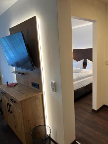 GlonnHotel Schwaiger的客房设有带一张床和一台平面电视的卧室。