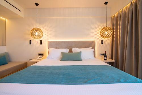 法里拉基Pegasos Deluxe Beach Hotel的一间卧室配有一张大床和两个吊灯