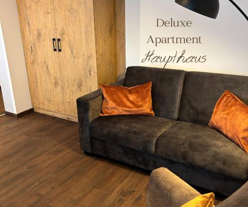 GlonnHotel Schwaiger的客厅里配有带橙色枕头的棕色沙发