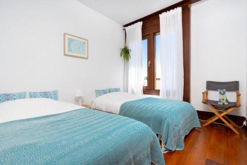 特罗亚GuestReady - Serene Hideaway in Troia的一间卧室设有两张床、一张桌子和一个窗口