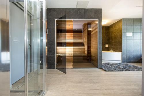 帕兰加Mana Suites & Sea的浴室设有玻璃步入式淋浴间和水槽