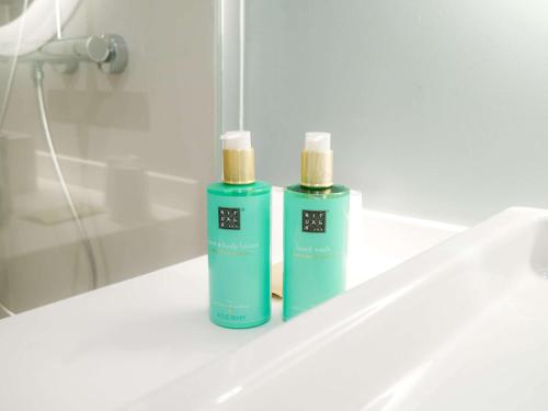 蒙特卡罗蒙特卡罗诺富特酒店的浴室水槽上放有两瓶绿的除臭剂