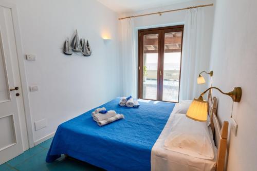 维拉西米乌斯Villa Tre Mari的一间卧室配有蓝色的床和毛巾