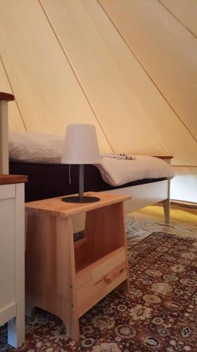 瓦尔斯罗德Glamping im 5 m Zelt auf dem Bauernhof的床头桌子上的一盏灯