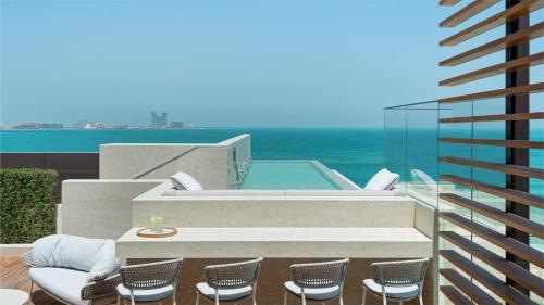 迪拜Jumeirah Al Naseem Dubai的大楼内带椅子和热水浴池的天井