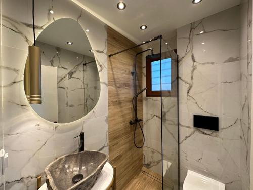 埃帕诺米Sea front Villa Myrat的带淋浴、卫生间和镜子的浴室